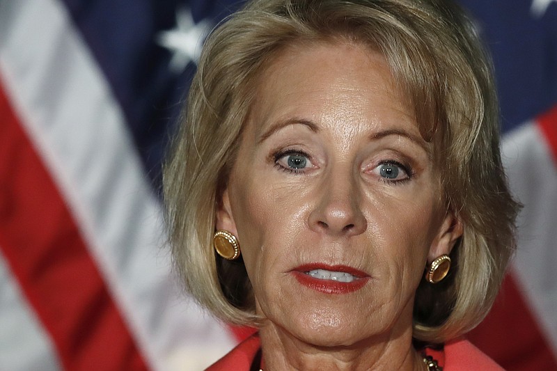 In this Sept. 7, 2017 photo, Education Secretary Betsy DeVos speaks at George Mason University Arlington, Va., campus.  Students who claim to have been defrauded by for-profit colleges may have to wait up to six more months before the Department of Education rules on their claims, according to a court document reviewed by the Associated Press.   (AP Photo/Jacquelyn Martin)