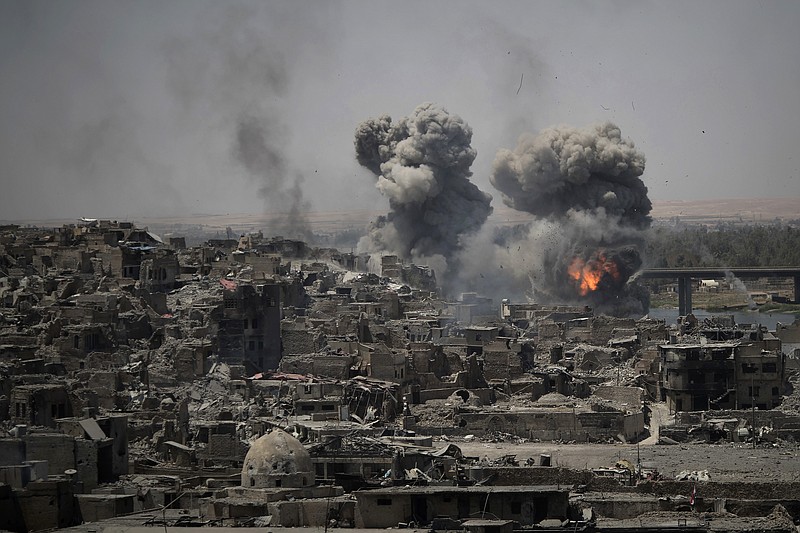 In this July 11, 2017 photo, airstrikes target Islamic State positions on the edge of the Old City a day after Iraq's prime minister declared "total victory" in Mosul, Iraq.  The U.S. military declassifies 81 locations of unexploded, coalition bombs dropped in Mosul in new effort to help aid groups and contractors clear explosives from Iraq's war-scarred cities.  (AP Photo/Felipe Dana)