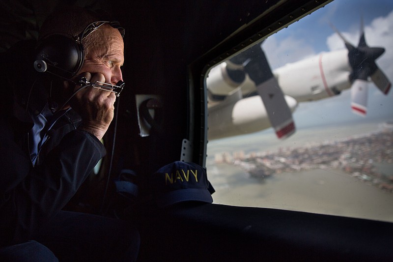 FILE - In this Monday, Sept. 11, 2017, file photo provided by the Governor's Press Office, Gov. Rick Scott looks out the window of a C-130 as he assesses damage to the Florida Keys during the aftermath of Hurricane Irma. Hurricane Irma delivered a serious punch to Florida agriculture but producers and officials have only barely begun to assess the damage to the state’s citrus, sugar cane and vegetable crops. (Jesse Romimora/Governor's Press Office via AP, File)