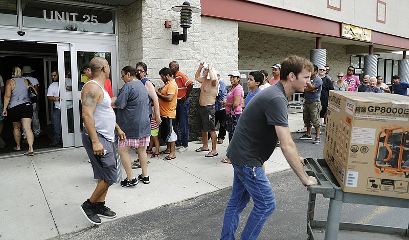 Customers wait in line to buy generators as many residents are still without power three days after Hurricane Irma passed through in Fort Myers, Fla., Wednesday, Sept. 13, 2017. (AP Photo/David Goldman)