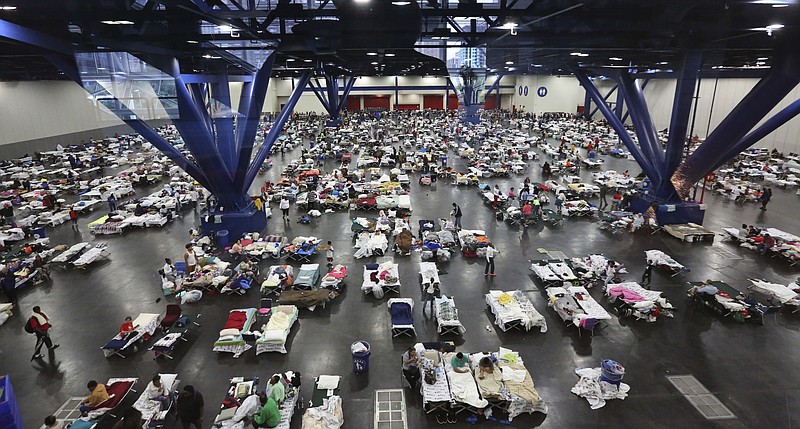 FILE - In this Tuesday, Aug. 29, 2017 file photo, evacuees escaping the floodwaters from Harvey rest at a Red Cross shelter set up in the George R. Brown Convention Center in Houston, Texas. After confronting back-to-back major hurricanes, the American Red Cross has received a huge outpouring of financial support _ and a simultaneous barrage of criticism. (AP Photo/LM Otero)