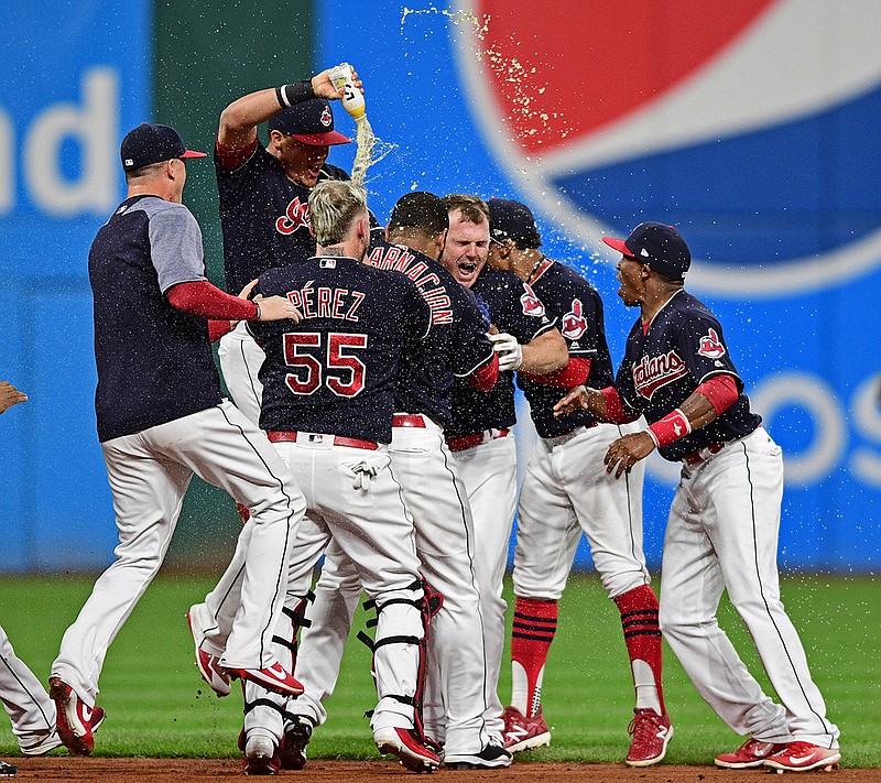 Cleveland Indians' Jay Bruce, center, celebrates with teammates after Bruce drove in the winning run with a double off Kansas City Royals relief pitcher Brandon Maurer during the 10th inning of a baseball game, Thursday, Sept. 14, 2017, in Cleveland. The Indians won 3-2. 