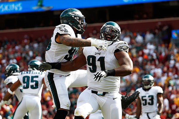 Eagles defensive tackle Fletcher Cox (91) celebrates with Derek Barnett after officials reviewed and confirmed a play in which Redskins quarterback Kirk Cousins fumbled and Cox recovered and scored a touchdown in the second half of Sunday's game in Landover, Md.