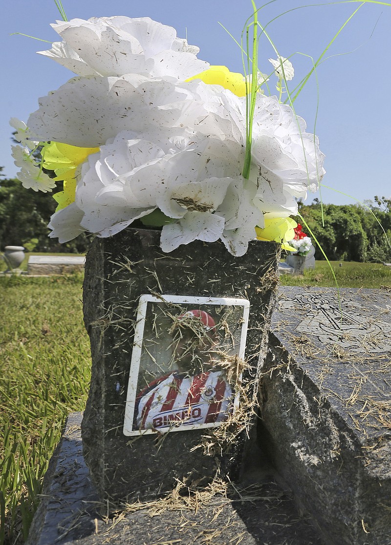 In this Sunday, Sept. 10, 2017 photo, debris from floodwater is strewn across a headstone at Hollywood Cemetery near downtown Houston. Hurricane Harvey floodwaters exposed dozens of caskets at swamped cemeteries in Texas and Louisiana last month, the grim result of shallow graves set in spongy soil, and a scene that may reappear as Florida cleans up after Hurricane Irma. 