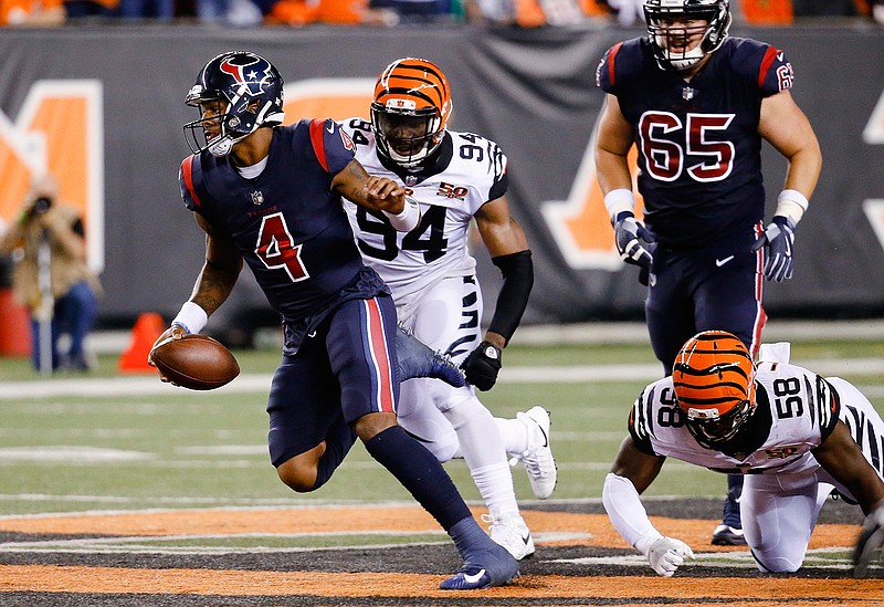 Houston Texans quarterback Deshaun Watson (4) breaks away from Cincinnati Bengals defensive end Chris Smith (94) and linebacker Carl Lawson (58) to score a touchdown during the first half of an NFL football game, Thursday, Sept. 14, 2017, in Cincinnati. 