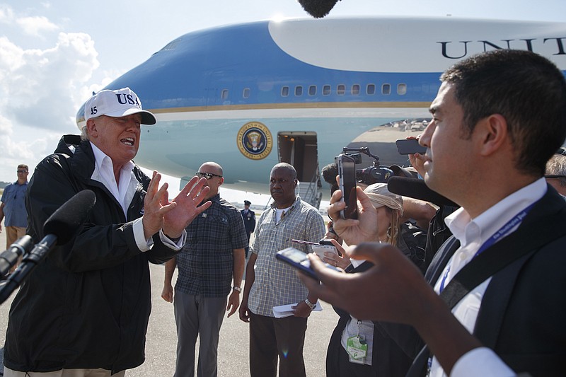 FILE - In this Thursday, Sept. 14, 2017, file photo, President Donald Trump talks with reporters after landing on Air Force One, in Fort Myers, Fla. Trump has taken a hard stand that slashing the corporate tax rate from 35 percent to as low as 15 percent would free up cash at these companies. The money would seep into worker paychecks and hiring would accelerate. “We’re going to have magnificent growth,” Trump declared aboard Air Force One on Thursday. “We’re going to go like a rocket ship.” But several economists, tax experts and even some business owners say that’s unlikely. (AP Photo/Evan Vucci)