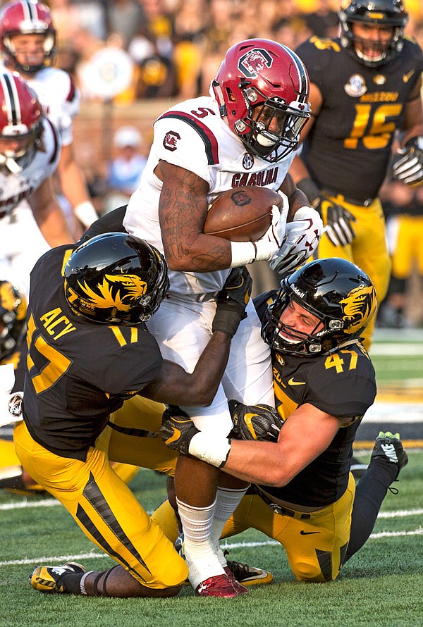 South Carolina running back Rico Dowdle is tackled by Missouri's Cale Garrett (right) and DeMarkus Acy during last Saturday's game at Faurot Field in Columbia.