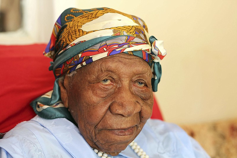 FILE - In this April 16, 2017 file photo, the world's oldest person Violet Brown poses for a photo at her home in Duanvale, Jamaica. Brown has died in Jamaica at the age of 117 years and 189 days old, on Friday, Sept. 15, at a local hospital. With her death, the Gerontology Research Group lists Nabi Tajima of Japan was the oldest surviving person. (AP Photo/Raymond Simpson, File)
