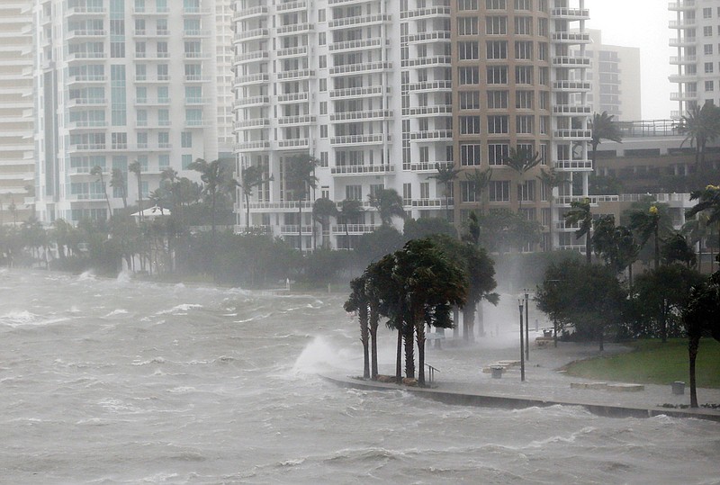 In this Sept. 10, 2017, photo, waves crash over a seawall at the mouth of the Miami River from Biscayne Bay, Fla., as Hurricane Irma passes by in Miami. Rising sea levels and fierce storms have failed to stop relentless population growth along U.S. coasts in recent years, a new Associated Press analysis shows. The latest punishing hurricanes scored bull's-eyes on two of the country's fastest growing regions: coastal Texas around Houston and resort areas of southwest Florida.