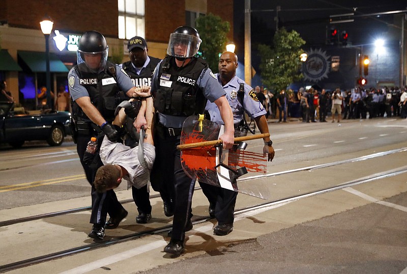Police arrest a man as they try to clear a violent crowd Saturday, Sept. 16, 2017, in University City, Mo. Earlier, protesters marched peacefully in response to a not guilty verdict in the trial of former St. Louis police officer Jason Stockley.