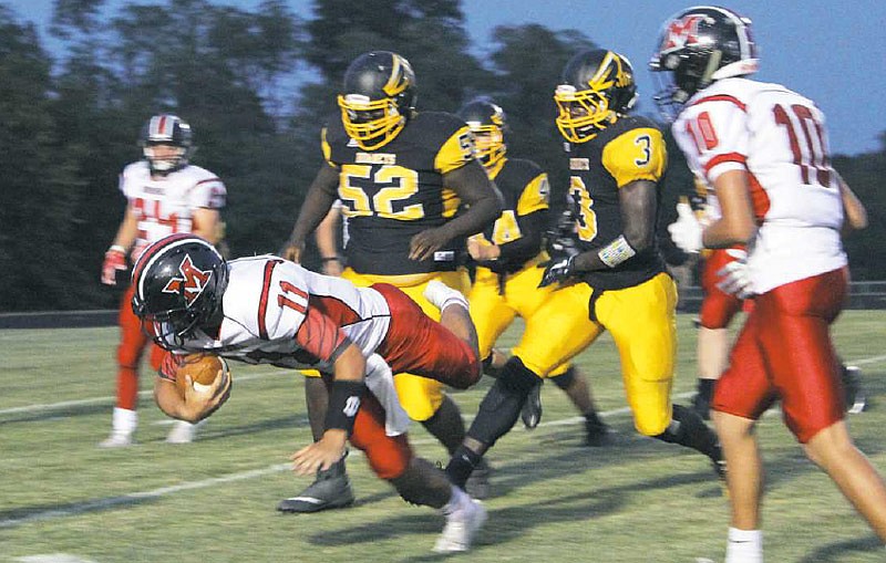 Senior outside linebacker Nazir McClain and other Fulton defenders swarm towards Marshall's senior quarterback John Haug Friday night, Sept. 15, 2017 at Robert E. Fisher Jr. Stadium.