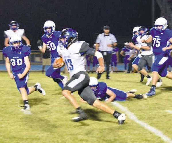 South Callaway senior quarterback Landon Horstman tries to distance himself from Montgomery County
defenders during the Bulldogs' 56-21 EMO romp over the Wildcats on Friday night, Sept. 15, 2017 in Montgomery
City.