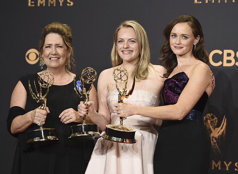 Ann Dowd, from left, winner of outstanding supporting actress in a drama series, Elisabeth Moss, winner of outstanding lead actress in a drama series, and Alexis Bledel, winner of outstanding guest actress in a drama for "The Handmaid's Tale" pose in the press room at the 69th Primetime Emmy Awards on Sunday, Sept. 17, 2017, at the Microsoft Theater in Los Angeles. (Photo by Jordan Strauss/Invision/AP)