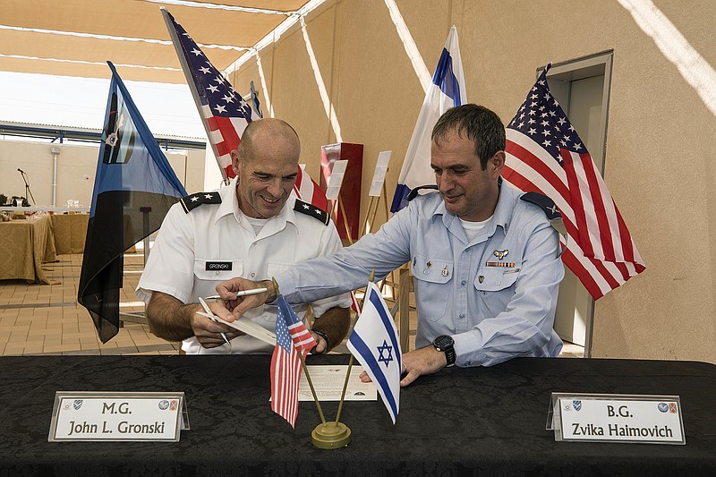 Israeli Defense Forces Brig. Gen. Zvika Haimovich, right, and U.S. Maj. Gen. John L. Gronski sign an agreement during a ceremony at the Bislach Air Base, near Mitzpe Ramon, Monday, Sept. 18, 2017. Israel and the United States announced plans Monday to open the first American air base in the Jewish state -- a facility that will aim to bolster Israel's aerial defenses. (AP Photo/Tsafrir Abayov)