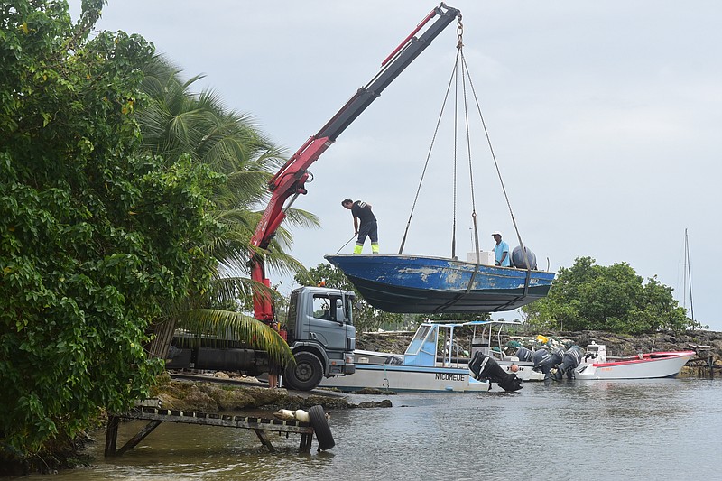 Men remove boats from the water ahead of Hurricane Maria in the Galbas area of Sainte-Anne on the French Caribbean island of Guadeloupe, early Monday, Sept. 18, 2017. Hurricane Maria grew into a Category 3 storm on Monday as it barreled toward a potentially devastating collision with islands in the eastern Caribbean. (AP Photo/Dominique Chomereau-Lamotte)