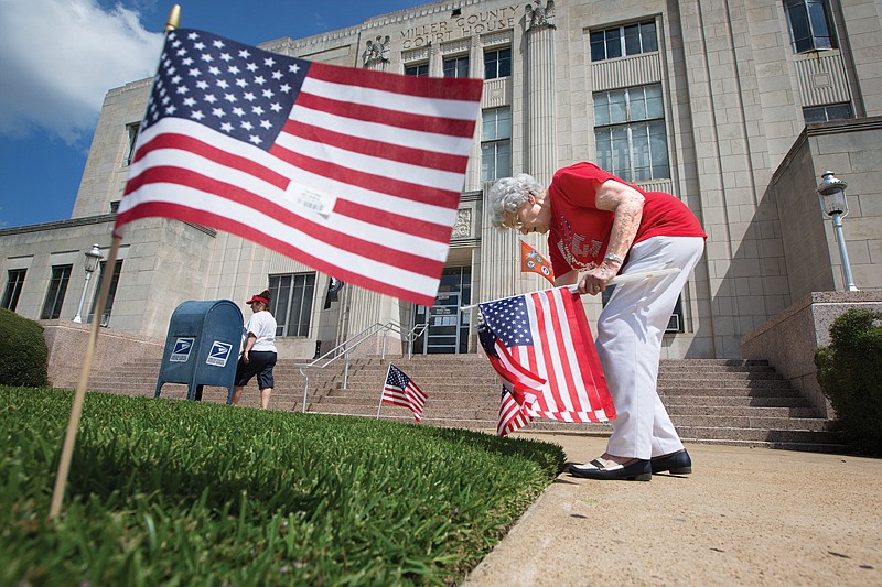 Dorothy Morgan with Arkansas Daughters of the American Revolution places flags on the lawn of the Miller County Courthouse on Monday. This is the fifth year the group put out flags to commemorate Constitution Week. DAR petitioned Congress in 1955 to recognize the week of Sept. 17-23 for the observation. The resolution was signed into law on Aug. 2, 1956, by President Dwight D. Eisenhower.