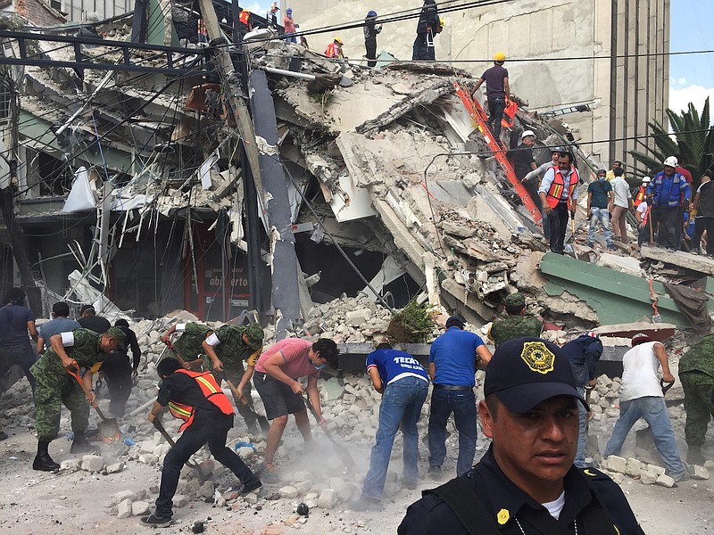 People search for survivors Tuesday, Sept. 19, 2017, in a collapsed building in the Roma neighborhood of Mexico City. A powerful earthquake has jolted Mexico, causing buildings to sway sickeningly in the capital on the anniversary of a 1985 quake that did major damage.