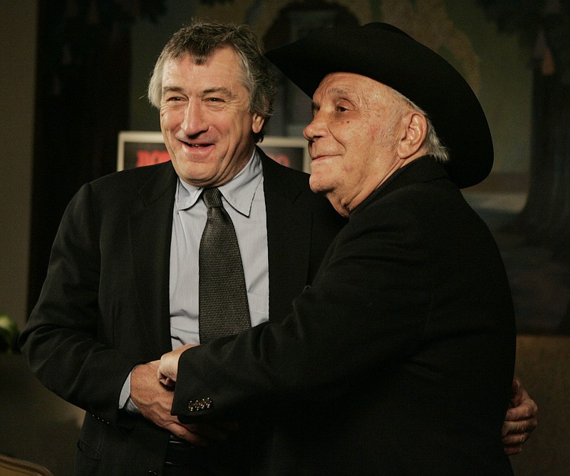 FILE - In this Jan. 27, 2005, file photo, Robert DeNiro, left, and boxer Jake LaMotta stand for photographers before watching a 25th anniversary screening of the movie "Raging Bull" in New York. LaMotta, whose life was depicted in the film “Raging Bull,” died Tuesday, Sept. 19, 2017, at a Miami-area hospital from complications of pneumonia. He was 95.  (AP Photo/Julie Jacobson, File)