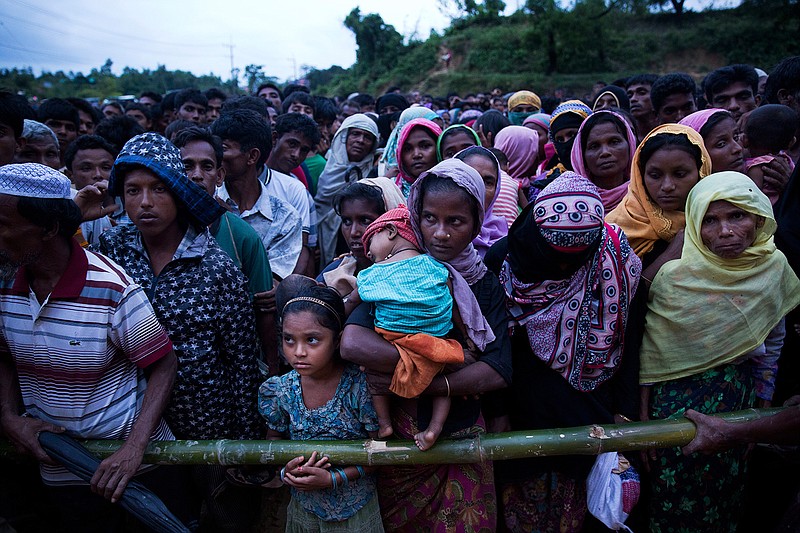 Rohingya Muslims, who crossed over recently from Myanmar into Bangladesh, stand in queues to receive food being distributed near Balukhali refugee camp in Cox's Bazar, Bangladesh, Tuesday, Sept. 19, 2017. More than 500,000 Rohingya Muslims have fled to neighboring Bangladesh in the past year, most of them in the last three weeks, after security forces and allied mobs retaliated  to a series of attacks by Muslim militants last month by burning down thousands of Rohingya homes in the predominantly Buddhist nation.