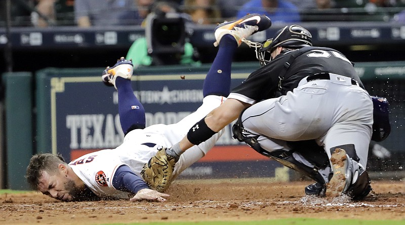 Houston Astros' George Springer, left, touches home plate to score as Chicago White Sox catcher Kevan Smith reaches to tag him during the eighth inning of a baseball game Tuesday, Sept. 19, 2017, in Houston. 