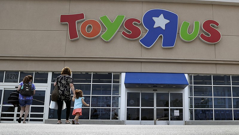 In this Tuesday, Sept. 19, 2017, photo, shoppers walk into a Toys R Us store, in San Antonio. Toys R Us may have filed for Chapter 11 bankruptcy protection this week, but the toy chain is revving up its holiday hiring. The Wayne, New Jersey-based retailer plans to hire more than 12,500 for the top six markets, which include Boston and New York. (AP Photo/Eric Gay)