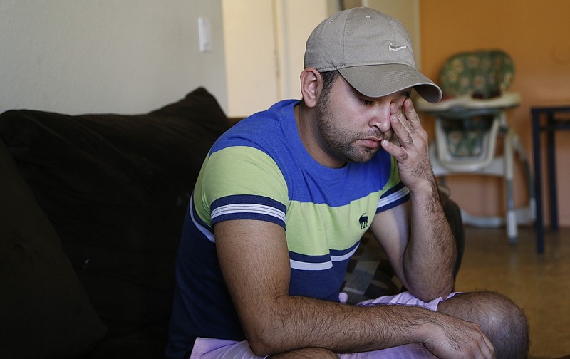 Cesar Garcia wipes his eye as he talks about how he and other family members survived the Payson, Ariz., flash flooding this summer that killed 10 other family members, at his home, Wednesday, Sept. 20, 2017, in Phoenix. (AP Photo/Ross D. Franklin)