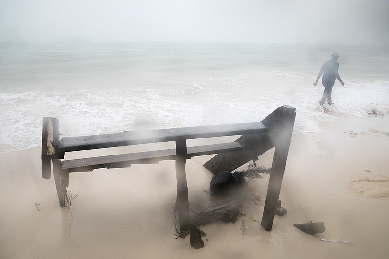 A person walks past a damaged staircase on Cofrecito Beach after the crossing of Hurricane Maria over Bavaro, Dominican Republic, Thursday, Sept. 21, 2017.  Rain from the storm will continue in the Dominican Republic for the next two days according to meteorologists.(AP Photo/Tatiana Fernandez)