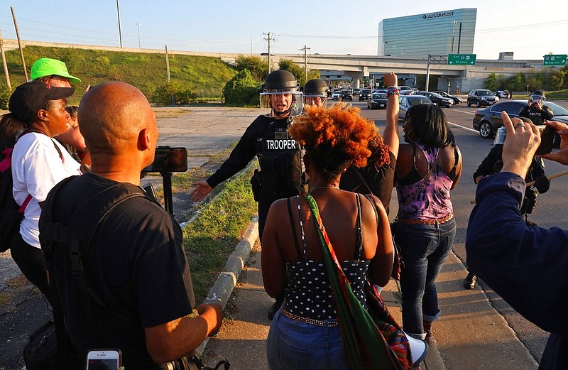 Police stop protesters from reaching the highway as they march at the Saint Louis Galleria mall in Richmond Heights Wednesday, Sept. 20, 2017, in St. Louis. Protests have taken place since Friday's acquittal of a white former St. Louis police officer for the fatal shooting of black drug suspect. (Christian Gooden/St. Louis Post-Dispatch via AP)