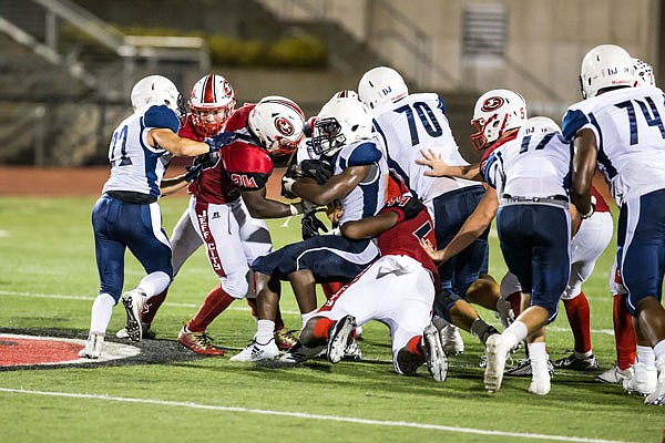 Jefferson City teammates Elijah Jackson and Corey Suttle combine to bring down a St Louis University High rusher during last Friday night's game at Adkins Stadium.