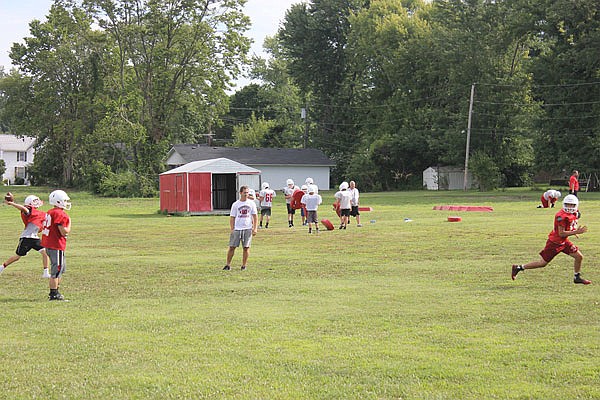 Tipton players work on a passing play during a preseason practice last month in Tipton.