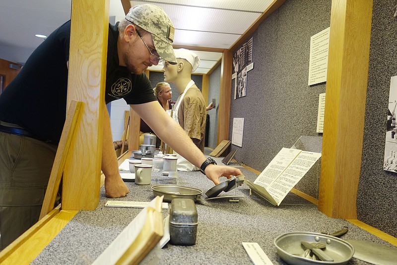 Brittany Hilderbrand/News Tribune  
University of Missouri students, Ben Truska and Haley Heil, put the finishing touches on the first ever military food exhibit Friday XXXX.