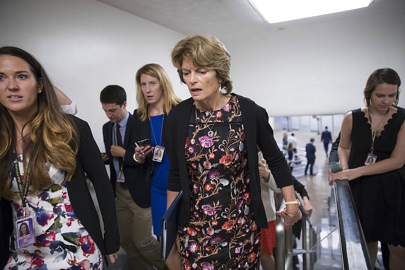 In this Sept. 19, 2017, photo, Sen. Lisa Murkowski, R-Alaska, speaks with a reporter as she arrives for a vote at the Capitol in Washington. Provisions shoehorned into the Republican health care bill dangle extra money for Alaska and Wisconsin, home states of one GOP senator whose vote party leaders desperately need and another who co-sponsored the legislation, according to analysts who've studied the legislation.