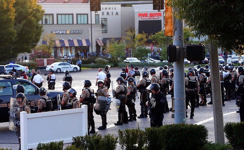 Police dressed in riot gear stage in the front of the Saint Louis Galleria mall to clear protesters from the streets on Wednesday, Sept. 20, 2017, in St. Louis. St. Louis County police say they broke up a demonstration near the upscale mall because protesters weren't listening to instructions and tried to evade two lines of officers blocking the on-ramp to a highway. The protesters broke into groups, with some milling around near the highway entrance, some in the mall parking lot and others on a nearby street. (Laurie Skrivan/St. Louis Post-Dispatch via AP)