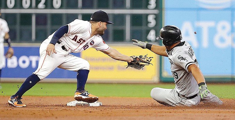 Chicago White Sox's Jose Abreu, right, avoids the tag by Houston Astros second baseman Jose Altuve as he slides safely into second with a double during the third inning of a baseball game Thursday, Sept. 21, 2017, in Houston. 