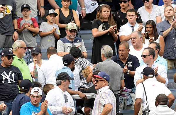 Fans react as a young girl is carried out of the seating area after being hit by a line drive during the fifth inning of Wednesday's game between the Yankees and Twins in New York.