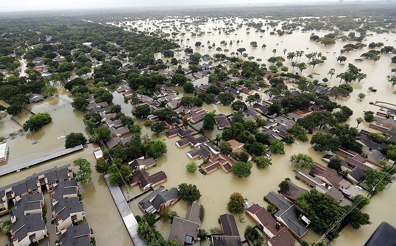 In this Tuesday, Aug. 29, 2017, file photo, water from Addicks Reservoir flows into neighborhoods as floodwaters from Harvey rise in Houston. Allstate expects $593 million in insurance losses for August due to Hurricane Harvey. That marks a spike from $181 million in July. The estimates do not include Hurricane Irma, which made landfall in September.