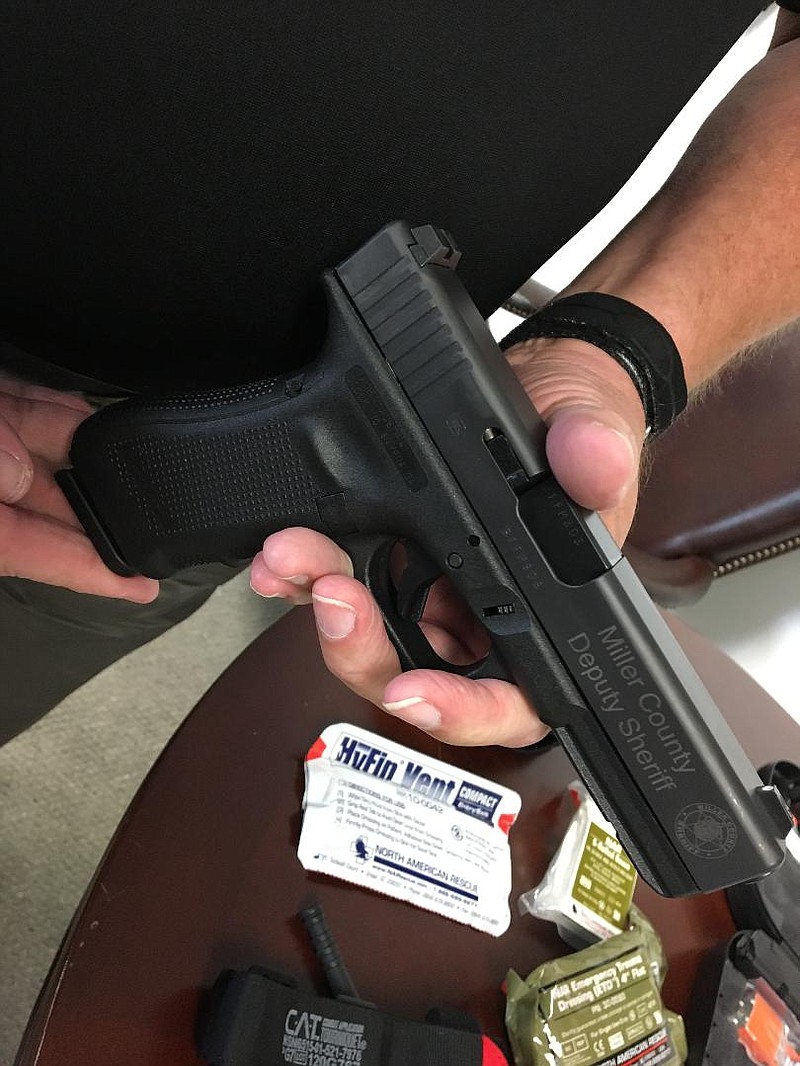 Miller County Sheriff Jackie Runion displays one of the new Glock pistols the department was able to pay for with money seized in drug-related arrests.
