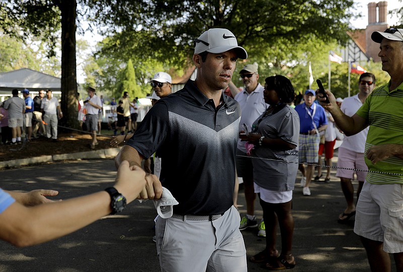 Paul Casey of England fist-bumps spectators as he walks off the ninth hole during the third round of the Tour Championship golf tournament at East Lake Golf Club in Atlanta, Saturday, Sept. 23, 2017. (AP Photo/David Goldman)