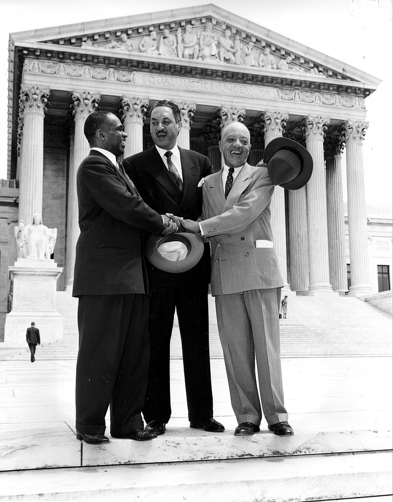 In this May 17, 1954, file photo, George E.C. Hayes, left, Thurgood Marshall, center, and James M. Nabrit join hands outside the U.S. Supreme Court in Washington, D.C., after justices declared in the Brown v. Board of Education decision that separate but equal schools for black children were unconstitutional. Three years after that ruling, President Dwight D. Eisenhower dispatched federal troops to Little Rock, Ark., to escort nine black children as they integrated Central High School. The 60th anniversary of the Little Rock Nine's enrollment is Monday, Sept. 25, 2017. 