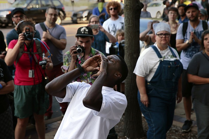 State Rep. Bruce Franks chants in front of the Buzz Westfall Justice Center as more than a hundred people wait for the release of almost two dozen people arrested earlier in the day at the Saint Louis Galleria mall, Saturday, Sept. 23, 2017, in Clayton, Mo. Demonstrations have been ongoing after a judge's ruling on Sept. 15 that found white former police officer Jason Stockley not guilty of first-degree murder in the 2011 shooting death of a 24-year-old black drug suspect Anthony Lamar Smith. (Robert Cohen/St. Louis Post-Dispatch via AP)