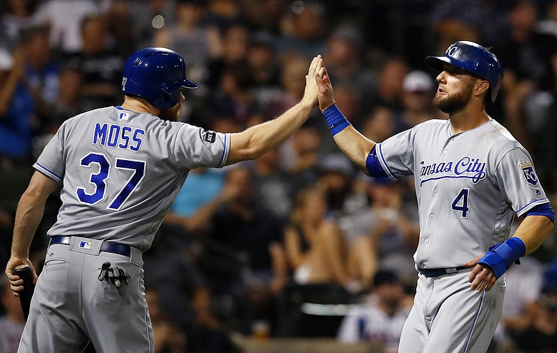 Kansas City Royals' Alex Gordon, right, celebrates scoring a run against the Chicago White Sox with teammate Brandon Moss during the seventh inning of a baseball game Saturday, Sept. 23, 2017, in Chicago. 