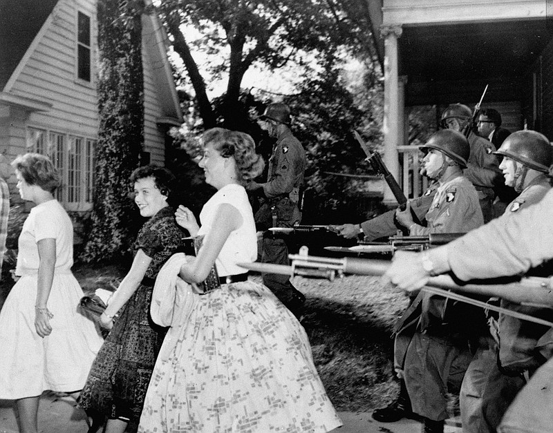 FILE - In this Sept. 25, 1957, file photo, white girls from Central High School laugh as troopers with bayonets force them to move in Little Rock, Ark. Federal forces were used to enforce integration in the face of racial tension in Arkansas. (AP Photo/File)