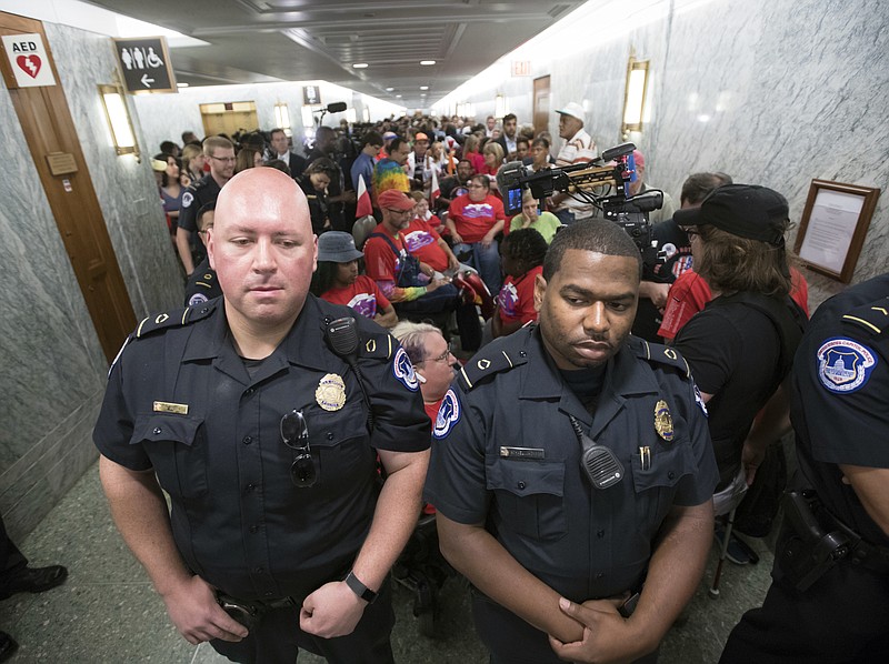 U.S. Capitol Police maintain order as hundreds of people, many with disabilities, arrive for a Senate Finance Committee hearing on the last-ditch GOP push to overhaul the nation's health care system, on Capitol Hill in Washington, Monday, Sept. 25, 2017. (AP Photo/J. Scott Applewhite)