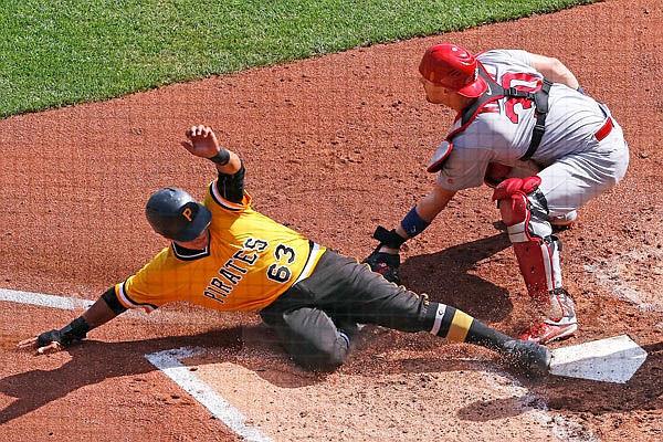 Pirates second baseman Chris Bostick scores on a sacrifice fly ahead of the tag by Cardinals catcher Carson Kelly in the third inning of Sunday afternoon's game in Pittsburgh.