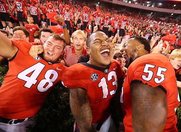 From left, Georgia's Jacob Gross, Jonathan Ledbetter and Dyshon Sims celebrate with fans after a 31-3 victory Saturday against Mississippi State in Athens, Ga.