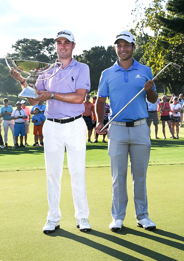 Justin Thomas (left) holds the trophy after winning the Fedex Cup, as he stands with Xander Schauffele who holds the trophy after winning the Tour Championship on Sunday at East Lake Golf Club in Atlanta.