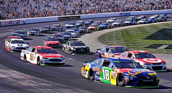 Kyle Busch (18) leads the pack into turn one in the first lap of Sunday's NASCAR Cup Series race at New Hampshire Motor Speedway in Loudon, N.H..