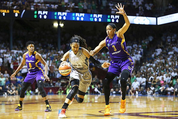 Lynx forward Maya Moore (23) drives the ball around Sparks center Candace Parker in the first half Sunday of Game 1 in the WNBA Finals in Minneapolis.