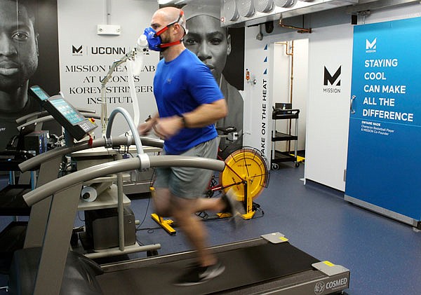 Ryan Curtis, associate director of athlete performance and safety for UConn's Korey Stringer Institute, runs on a treadmill Thursday at the institute's Mission Heat Lab in Storrs, Conn. The new $700,000 lab allows scientists to monitor how athletes, soldiers and others respond to temperatures of up to 110 degrees and 90 percent humidity.