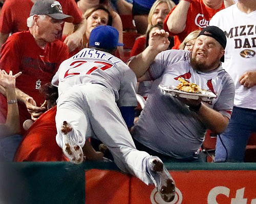 Cubs shortstop Addison Russell dives into the crowd but is unable to catch a foul ball hit by Jedd Gyorko of the Cardinals during the second inning of Monday night's game at Busch Stadium.